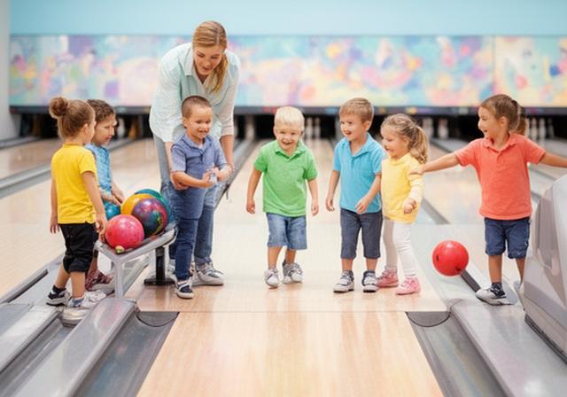 Kita-Gruppe mit Betreuungsperson beim spielerischen Bowling in Schneeberg